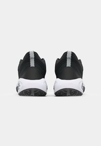 Black athletic shoes with a textured mesh upper and white rubber soles. Features a reflective heel tab and patterned outsole for traction.