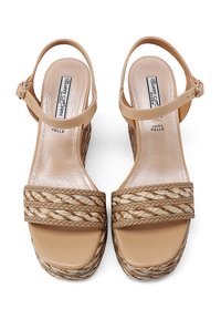 Sandali platform beige con dettagli in fibra naturale intrecciata, cinturino alla caviglia regolabile e soletta liscia e lucida. Presentano un design con tacco a blocco.