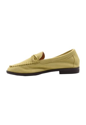 Mocassino giallo in suede con tacco basso nero, cuciture in stile mocassino e dettaglio con fiocco sulla parte superiore, mostrato di profilo su sfondo bianco.