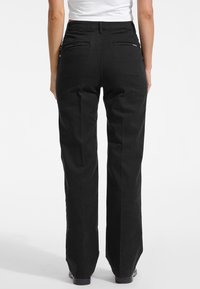 Crne hlače širokih nogavica od pamuka, s dva stražnja džepa, glatke teksture i klasičnog dizajna. Idealne za ležerno nošenje.