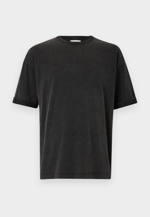 Svart t-skjorte med korte ermer, rund hals, avslappet passform og oppbrettede ermer. Laget av myk bomullsstoff med en lett tekstur.