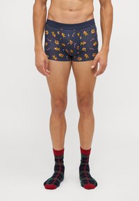 Marina boxershorts med pepparkaksgubbar och sockerstångsmönster; elastisk midja; matchas med röda och gröna rutiga strumpor, medellång längd.