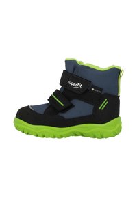 Stivale alla caviglia blu e nero con accenti verdi, caratterizzato da una parte superiore testurizzata, due cinturini in velcro e una suola robusta per la trazione. Materiale Gore-Tex.