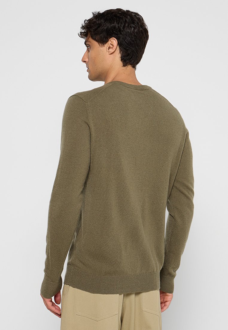Pull vert olive, col rond, manches longues, en tissu tricoté, avec des poignets et un ourlet côtelés, texture lisse et design ajusté.