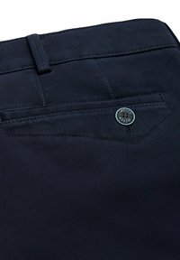 Dunkelblaue Hose aus strukturiertem Stoff, mit einer Gesäßtasche mit dreieckiger Klappe und einem runden Knopf mit eingeprägtem "MEYER".