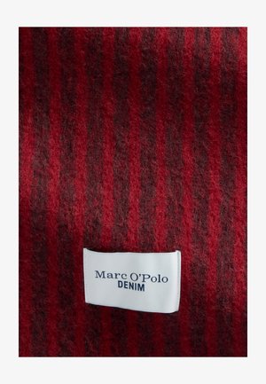 Rood en donker gestreept stof met een wit rechthoekig Marc O'Polo Denim merklabel dat dicht bij het midden onderaan is genaaid.