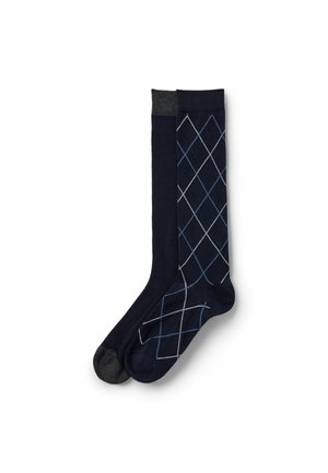 Calzini blu navy con texture a costine; uno è uniforme con una punta grigia, l'altro presenta un motivo a rombi in azzurro chiaro e bianco.
