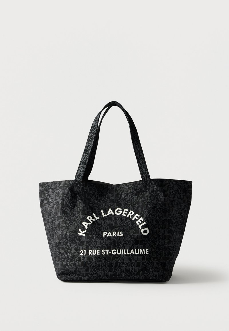 Μαύρη τσάντα tote με επαναλαμβανόμενο μοτίβο κειμένου "KARL LAGERFELD" και λευκό κείμενο "KARL LAGERFELD PARIS 21 RUE ST-GUILLAUME" μπροστά.