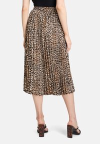 Plisowana spódnica midi w panterkę w beżowym i czarnym kolorze, z elastycznym pasem, lekki materiał, gładka faktura i zwiewny fason.