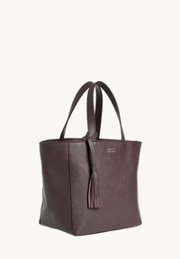 Sac fourre-tout en cuir violet foncé avec des poignées doubles et un détail de frange sur fond uni.