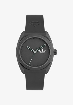 Zwarte horloge met een matte afwerking, ronde wijzerplaat, groene uur- en minuutwijzers, zilveren secondewijzer en een klein wit logo op de wijzerplaat.