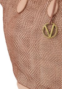 Gewoven rieten schoudertas in lichtroze, met een ronde messingen bedel met "Venezia" gegraveerd. Soepele leren accenten aan de hengsels.