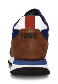 Scarpa sportiva blu e marrone con texture in suede e rete, caratterizzata da un accento rosso, un tallone bianco e il numero "1968" sul retro.