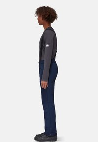 Spodnie narciarskie z regulowanymi szelkami, wykonane z granatowego materiału. Posiadają boczne kieszenie na zamek oraz wzmocnione mankiety. Połączone z szarym topem z długim rękawem.