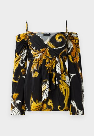 Mustmust suits, mille ja valge lillemustriga. Omab õlavarre ületavat disaini, pikki varrukaid ja lipsuga vööd. Valmistatud kergest kangast.