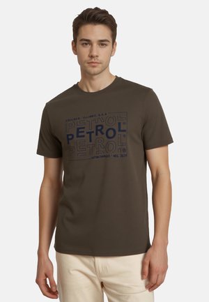 Camiseta de algodón verde oscuro con un estampado gráfico azul con la palabra "PETROL" en diversas posiciones. Mangas cortas y escote redondo.