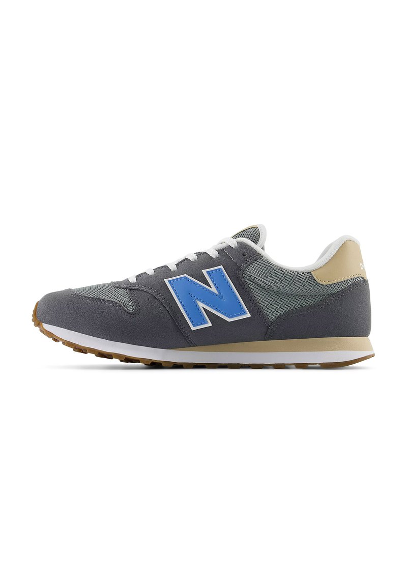 Sneaker atletiche grigie con upper in rete, logo "N" blu, lacci bianchi e accenti beige chiaro sul tallone, dotate di suola in gomma.