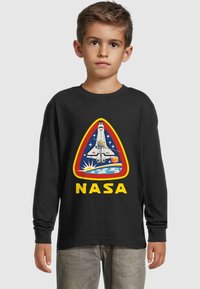 Sort langærmet skjorte med en farverig NASA-grafik, der viser en rumfærge, en planet og stjerner, sat inden for et trekantet design.