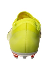 Botín de fútbol amarillo con una parte superior suave y ligera, talón texturizado y tachuelas naranjas sobre una suela blanca. Cuenta con un cuello acolchado para mayor soporte.