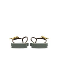 Bruine rubberen slippers met groene, gestructureerde zolen. Beschikt over een gouden accent in de vorm van een hagedis op de band. Eenvoudig en vlak ontwerp.