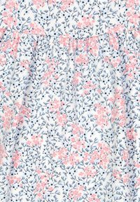 Tkanina w kwiatowy wzór ma małe różowe kwiaty i zielone liście na białym tle, z marszczonym szwem dla uzyskania faktury.