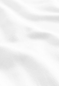 Tela blanca con una superficie lisa y ligeramente texturizada que presenta líneas diagonales sutiles y pliegues que crean suaves ondas.