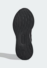 Suola di scarpa sportiva nera con pattern di grip testurizzato, featuring scanalature orizzontali e verticali per trazione e stabilità.