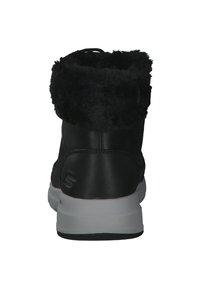 Stivali neri alla caviglia con colletto in finta pelliccia, realizzati in pelle e gomma, caratterizzati da un design imbottito e una suola bianca a contrasto.