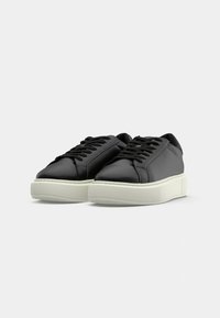 Black leather shoes with a smooth texture, round toe, and thick white rubber sole; features laces and simple design.