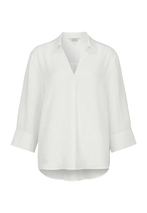 Blouse blanche à manches longues 3/4, col en V, col chemise, et ourlet légèrement arrondi.