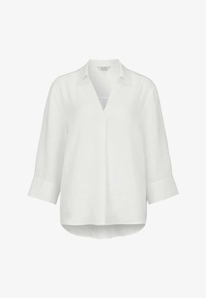 Blouse blanche à manches longues 3/4, col en V, col chemise, et ourlet légèrement arrondi.