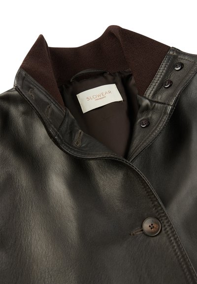 Braune Lederjacke mit einem gerippten Kragen, ausgestattet mit Knöpfen und einer glatten Textur. Innenfutter mit sichtbarem Markensiegel.