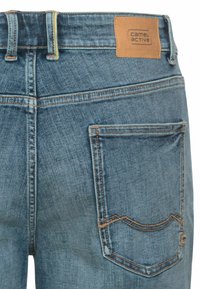 Denimjeans i mellemblå med et lædermærke, kontraststing og et standard design til baglommen.