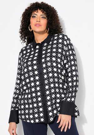 Zwart-witte blouse met lange mouwen en een geometrisch ruitpatroon, voorzien van een kraag, knoopsluiting en contrasterende manchetten.