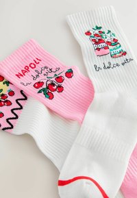Knee-high sokid roosades, valgetes ja mustrilistes kangastes; sisaldavad kirsikujutisi, teksti "NAPOLI" ja "la dolce vita", ribakujundusega.