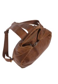Bolso de cuero marrón con forma flexible, que cuenta con cierre superior de cremallera, correa de tela marrón ajustable y detalles de textura sutiles.