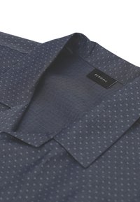 Camicia blu navy con piccolo motivo a pois bianchi, colletto aperto e etichetta nera "PEROFIL" cucita all'interno del colletto.