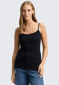 Zwarte geribbelde tanktop met dunne bandjes, gestroomlijnde pasvorm en een gladde textuur. Gekocht met ontspannen blauwe jeans voor een casual look.