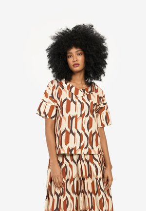 T-shirt med korte ærmer, der har et abstrakt mønster i brun og creme, med en let bred udskæring og en afslappet pasform. Glat stoftekstur.