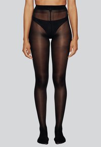 Collant neri opachi con vita alta. Texture trasparente dalla vita alla caviglia. Presenta una finitura liscia e senza cuciture visibili.