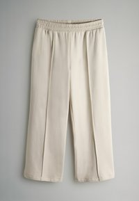 Beige Hose mit elastischem Bund, plissierter Vorderseite, weitem Bein und einer glatten, weichen Textur. Keine sichtbaren Taschen oder zusätzlichen Beschläge.