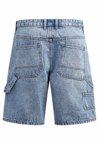 Shorts de mezclilla en azul claro, con un corte holgado, dos bolsillos traseros y un bolsillo lateral con un acabado texturizado y costuras visibles.