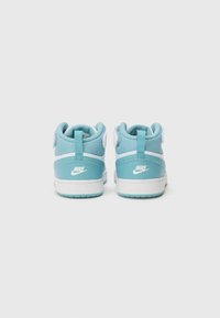 Baskets Nike avec une tige bleu clair, des accents blancs, un design montante, un matériau en maille texturée et un col rembourré pour le soutien.