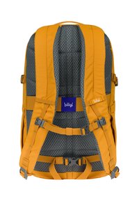 Zaino di stoffa giallo con imbottitura in rete grigia, spallacci regolabili e molteplici fibbie. Presenta un grande patch con logo blu.