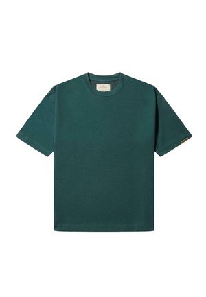 Camiseta de algodón verde con mangas cortas, cuello redondo y una etiqueta en la manga izquierda. La tela parece suave y uniforme en color.