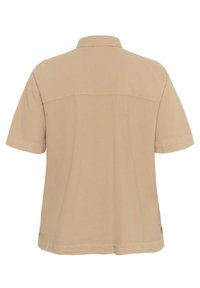 Chemise beige à manches courtes en tissu lisse, dotée d'un col classique et d'un empiècement au dos avec un discret détail de couture.