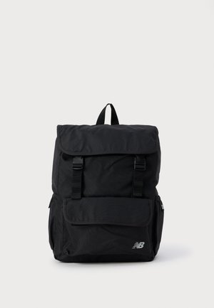 Mochila negra hecha de un tejido duradero con solapa plegable, correas ajustables, bolsillo frontal y un acento de logo plateado.