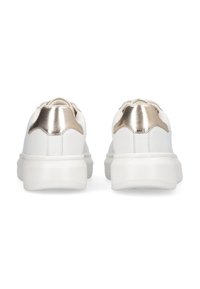 Un par de zapatillas blancas con suelas gruesas y acentos en dorado metálico en el talón, vistas desde atrás sobre un fondo blanco.