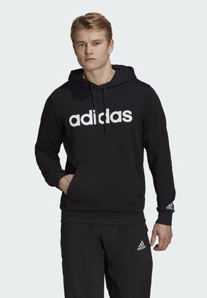Black hoodie made of soft fabric, features a large white "adidas" logo on the front, adjustable drawstring hood, and front kangaroo pocket.