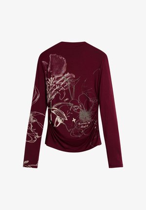 Camisa de manga larga rojo oscuro con patrones florales claros y líneas abstractas, que incluyen texto estilo manuscrito y pequeños acentos gráficos.